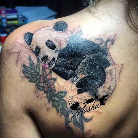 Обаятельный медведь панда нашел путь к сердцам самых суровых почитателей тату культуры. Его шарм способен расположить к себе любого зрителя. Несмотря на свой комичный внешний вид панда остается сильным зверем, способным на атаку. Двойственная натура мишки стала мемом в мире татуировок. Тату панда значение Предположительно тату панда появилось на рубеже 70-х годов. Животное получило свое место в пантеоне геральдических зверей тату благодаря распространению хики. Это течение было связано с преображением граффити. Появляющиеся рисунки несли аллегорический смысл, строились по принципу противоречия. Все что символизирует панда как бы делится на 2 половины. С одной стороны это миролюбие, дружба и светлые помыслы. С другой пушистый зверек воплощает скрытые намерения, агрессию и кипящие страсти желающие выйти наружу. Такое значение панда приобрела после случая в 1978 году, когда смотритель лондонского зоопарка попытался отобрать игрушку у животного. Предмет попал в вольер по случайности, но медведю она сильно понравилась. Желая защитить приобретение пушистое создание покусало и серьезно поранило человека. Тату панда значение для парней и девушек Изображение на теле для девушек несет значение творческой личности готовой к непредсказуемым поворотам судьбы. Фигура может изображаться в центре мандала, такая тату панда значение несет умиротворение и гармония. Образ зверя несет значение для мужчин в качестве аллегории мягкости и агрессии. Рассматривая характер изображения легко понять его смысл. Если пушистый медведь занимается привычными занятиями, это положительный знак. Владелец любит юмор и не склонен к опрометчивым действиям. Панда с оскаленной мордой символ предупреждения, носитель не намерен терпеть вмешательство в свое внутренне пространство. Панду с банданой часто красного цвета набивают путешественники. Прародителем образа стала игрушка, сделанная для завода Steiff в 1938 году. Первый экземпляр стал участником международной выставки и объехал весь Мир. Варианты татуировок с пандой У рисунка множество типов исполнения. Популярность набирает тату панда в стиле геометрия. Само животное может быть изображено частично реалистично. Его окружают геометрические линии. Или вся фигура выложена разными фигурами. В черно-белом стиле панду набивают в виде контура. За основу берут популярное изображение с логотипа лондонского зоопарка. Если девушка или молодой парень хотят совсем маленькую панда тату в таком духе наиболее удачно воплотит их задумку. Чаще всего зверя изображают с бамбуком милый детеныш панды играет со стеблями. Наследием культуры хики стала панда с пистолетами. В этом рисунке чувствуется юмор. Пушистый увалень держит 2 кольта и угрожает окружающим. Рисунок может нести негативных и даже злой характер. Злую панду изображают в окружении красных пятен. Форма морды может выражать агрессию и желание напасть. Места нанесения тату панда Для девушек лучшим местом считается область на руке в районе предплечья. Множество татуировок панды набивается в 2 цветах. Цветами дополняются только средние или крупные изображения. Мужчины бьют медведя: • на груди; • на ребрах; • на ноге в районе икры; • на плече и лопатке. Красиво смотрится композиция из оттенков серого, белого и голубого на фоне зеленых побегов бамбука. Выбирая тату в стиле реализма, носитель получает фото картину на коже. Одной из нашумевших работ в аналогичном стиле стала морда панды смотрящая на зрителя из эвкалиптовых зарослей. Рисунок был нанесен на область плеча с переходом в спину. Советы для эскизов Хотите получить красочный визуальный эффект, доверяйте эскизы мастеру выполняющему ваш заказ. Для небольших работ будет достаточно поработать над позой животного. На небольшом изображении нет смысла добавлять большое число деталей. Панно размерами от 10Х10 см другое дело. Художник может развернуться, создав целый сюжет. Пушистого медведя изображают в стилях: • трэш полька; • акварель; • реализм; • геометрия; • с элементами орнаментал; • нью скул. Удачными позами считается лежащая, стоящая и сидящая в пол оборота панда. Если зверь атакует и дополнен предметами, мастер должен максимально изучить прямостоячие атакующие позы медведей. После чего рисунок будет смотреться достаточно выигрышно.